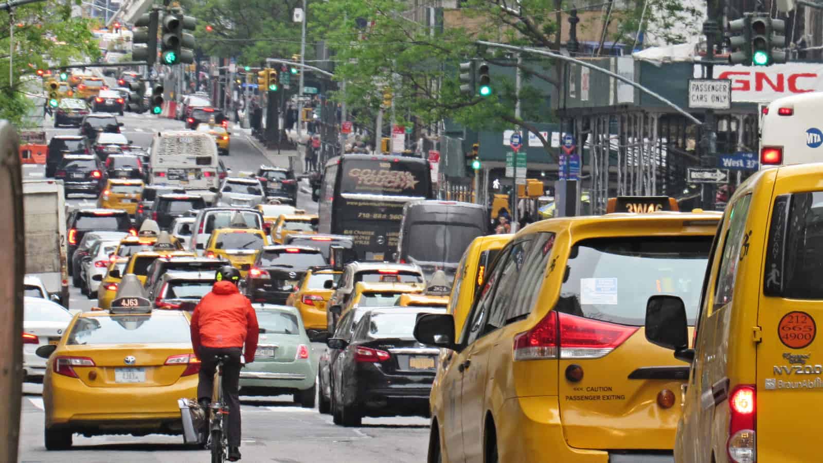 Yellow taxicabs, bicycle messengers and private cars jockey for space on 5th Ave. in midtown Manhattan